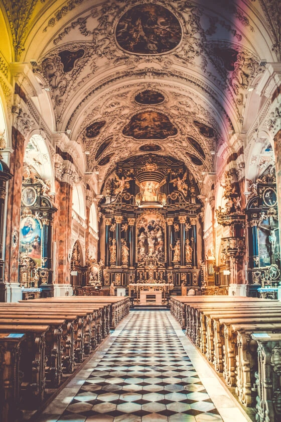 beautiful church sanctuary and altar with stained glass windows and ornate architecture in background